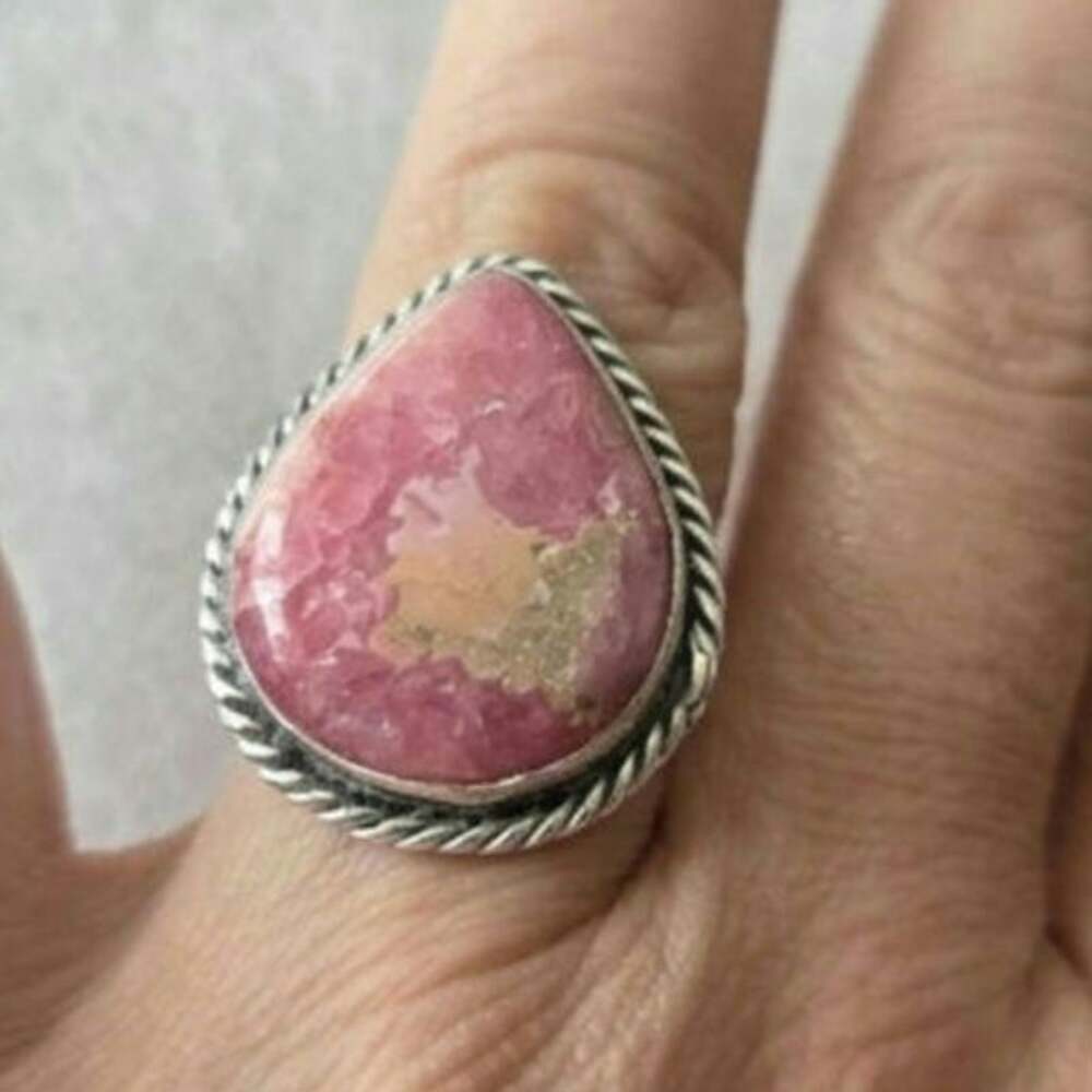 Teardrop-shaped pink rhondite stone set in a sterling silver twisted rope border